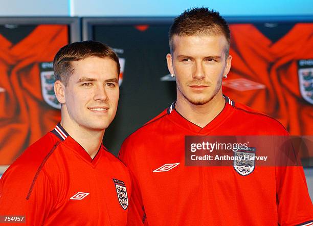 England soccer team captain David Beckham and teammate Michael Owen model the new England away strip--a red short-sleeved shirt, white shorts and red...