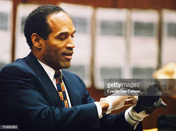Simpson tries on a leather glove allegedly used in the murders of Nicole Brown Simpson and Ronald Goldman during testimony in Simpson's murder trial...