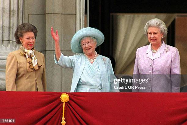 Princess Margaret and Queen Elizabeth stand next to the Queen Mother as she waves to admirers on the occassion of her 100th birthday celebration...