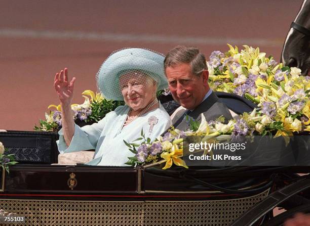 Prince Charles sits next to the Queen Mother as she waves to admirers on the occassion of her 100th birthday celebration August 4, 2000 in London....