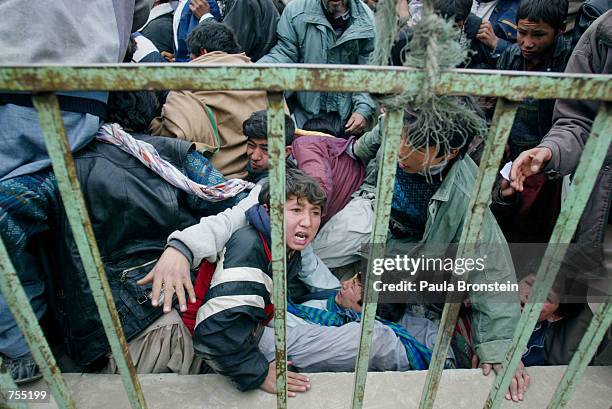 Thousands of Afghans battle to get into the Olympic stadium February 15,2002 to see the "Game of Unity" soccer match between Kabul United and the...