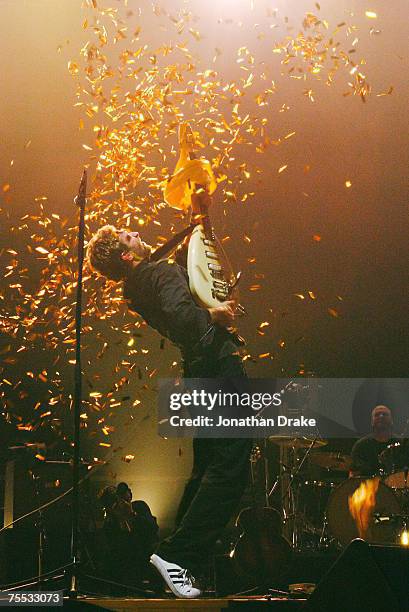 Coldplay lead singer Chris Martin bursts a balloon with his guitar at the Singapore Indoor Stadium in Singapore, Singapore.