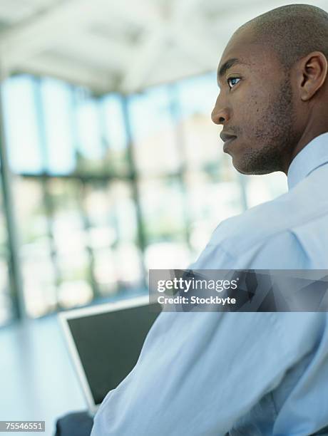 businessman using laptop,profile,upper half - half shaved hair stockfoto's en -beelden