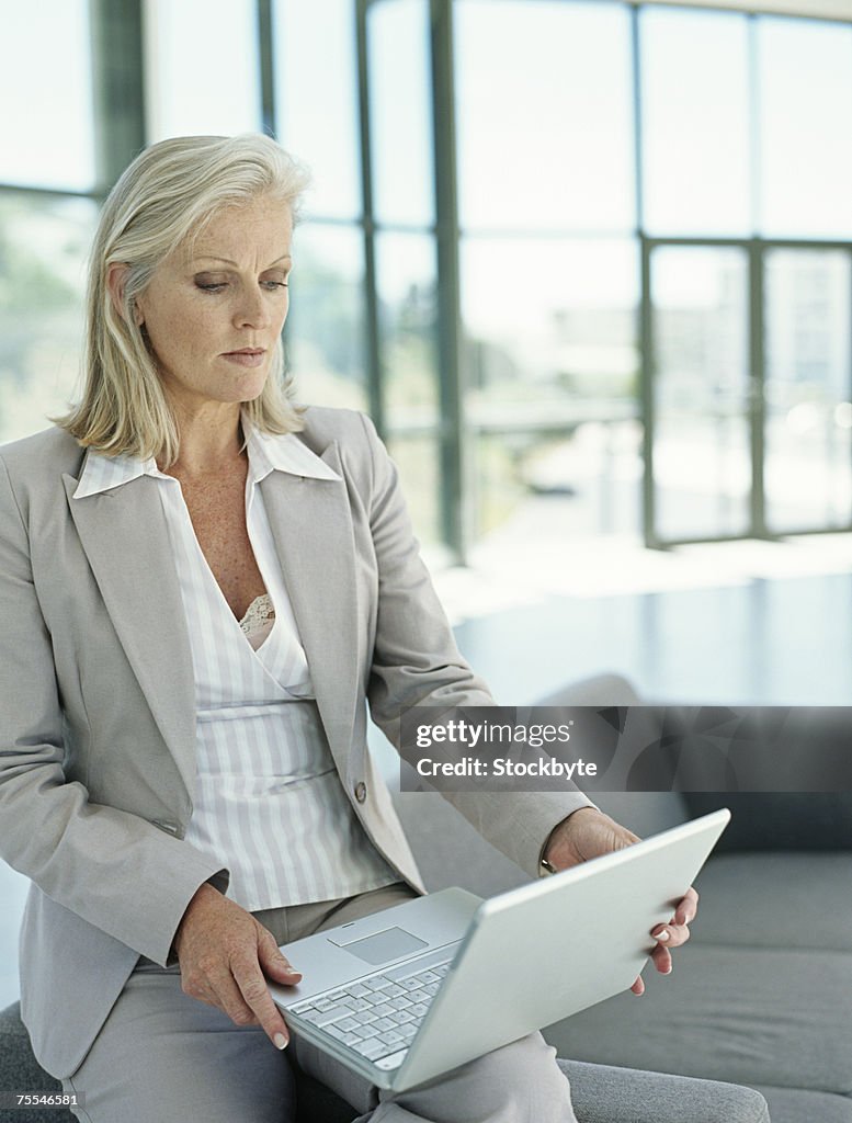 Business woman using laptop,three quarter length