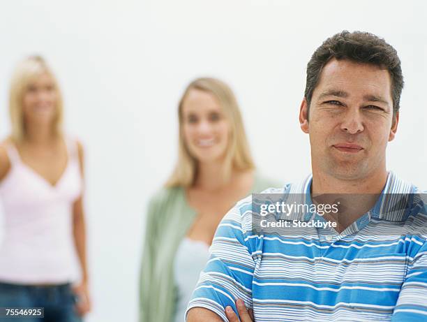 man with two women standing in studio,focus on man in foreground - 40s woman t shirt studio imagens e fotografias de stock