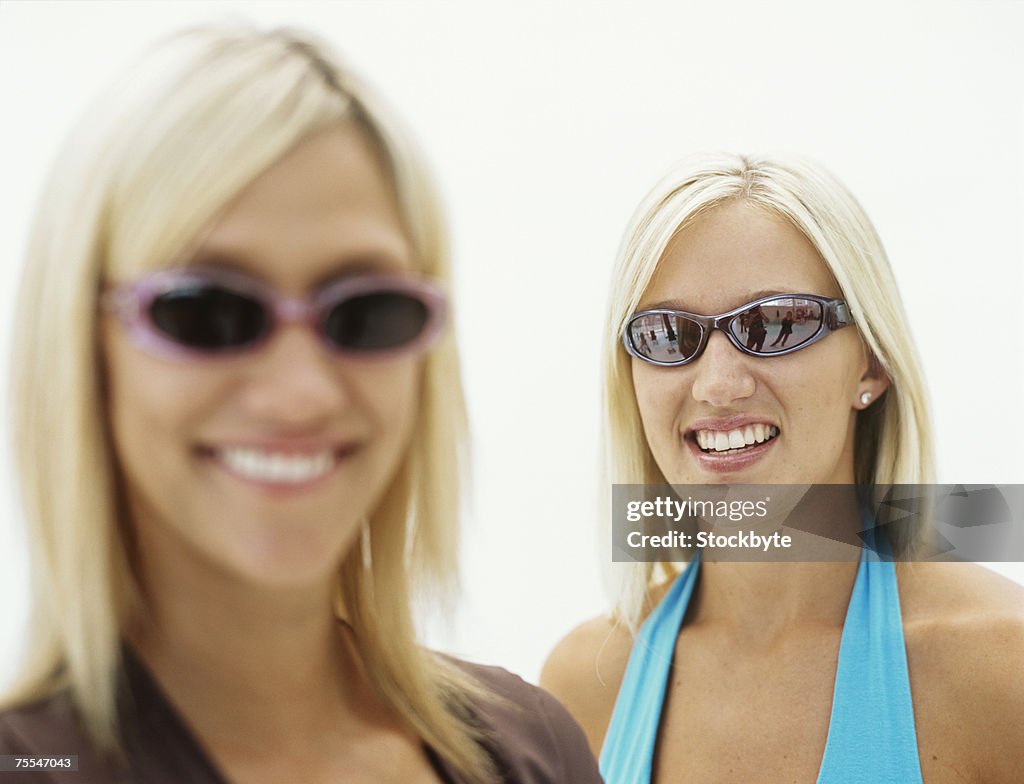 Portrait of two women wearing sunglasses,smiling,differential focus