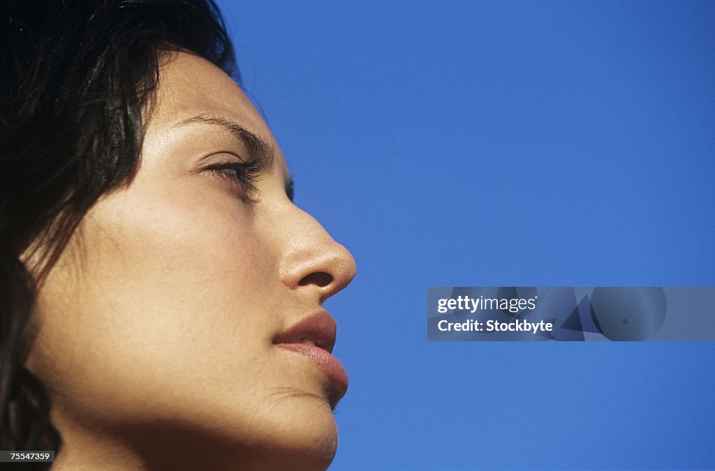 Young woman against clear sky,profile,close-up,low angle view
