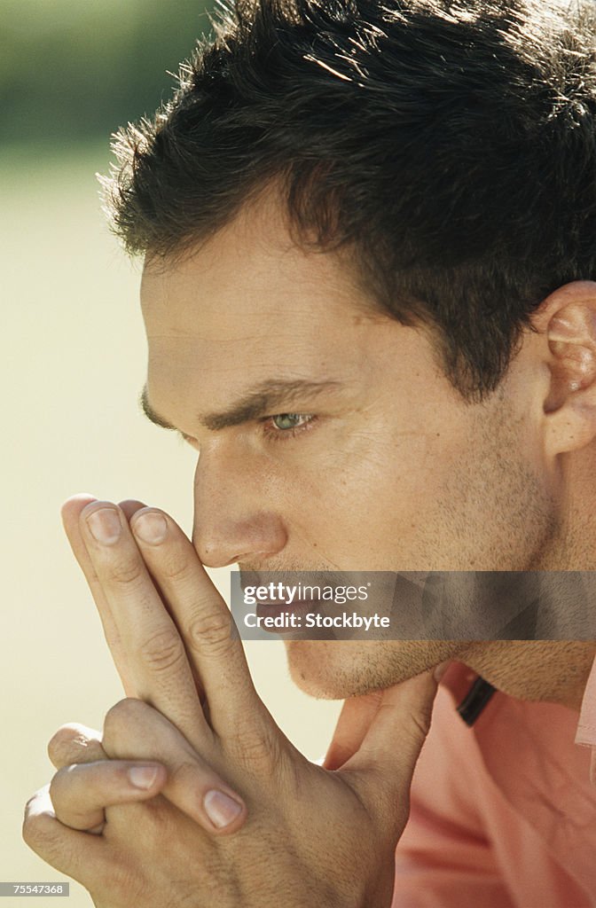 Young man with hands clasped,profile,close-up