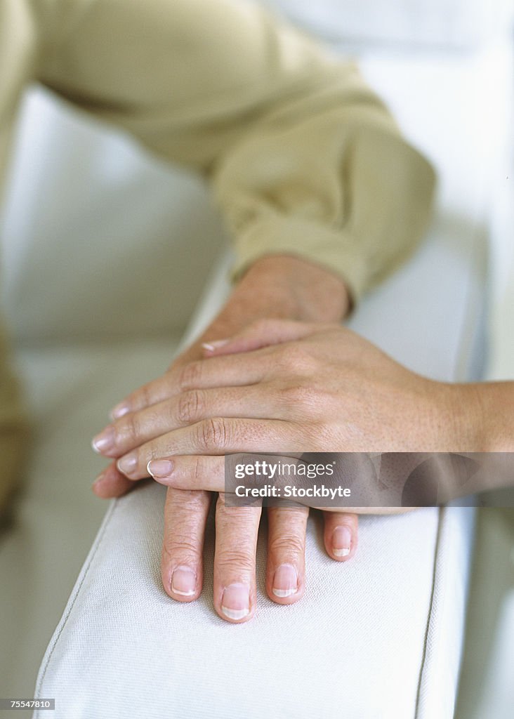 Hands Rested Together Front Two Peoples Hands Together On Arm Of Sofa Closeup High-Res Stock Photo ...