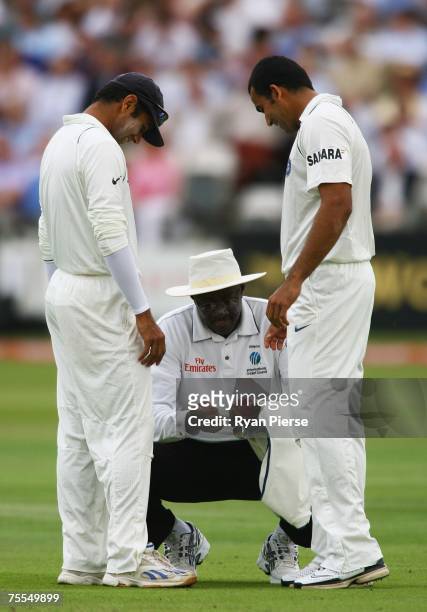 Indian captain Rahul Dravid inspects the ball with team mate Zaheer Khan and umpire Steve Bucknor during day one of the First Test match between...