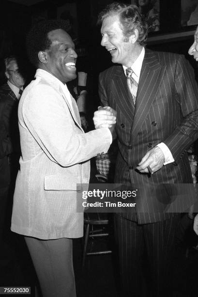 American comedian and actor Nipsey Russell and politician and New York mayor John Lindsay laugh as they clasp hands at an unidentified event, early...