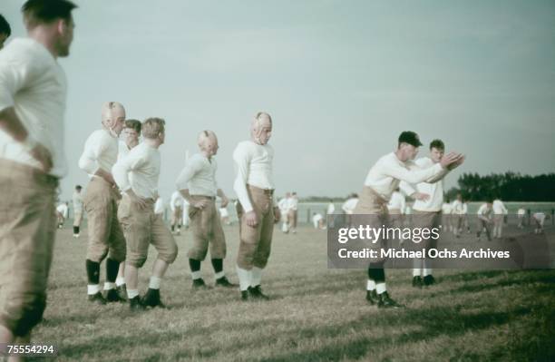 The coach instructs his players during a high school football practice circa 1939.