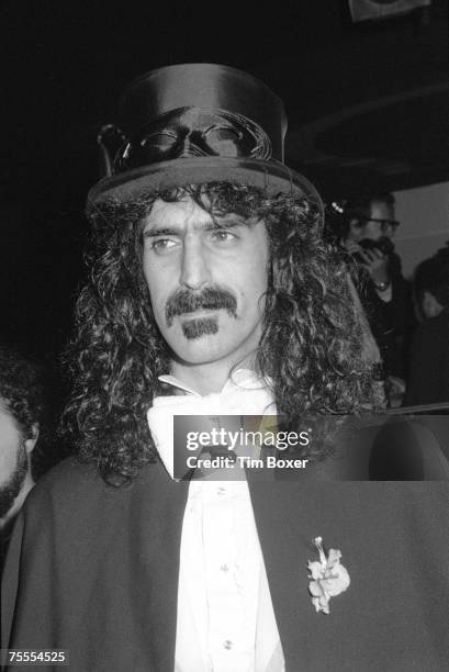 Portrait of American musician Frank Zappa dressed in a cape and top hat over a white vest, shirt, and bow tie, 1970s.