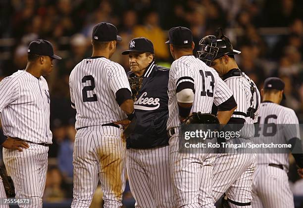 Joe Torre and members of the New York Yankees look on the mound against the Boston Red Sox on April 27, 2006 in the Bronx borough of New York City...