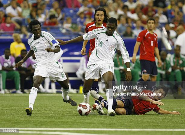 Chukwuma Akabueze and Ezekiel Bala of Nigeria looks to control the ball as Gary Medel of Chile falls to the ground during the Quaterfinal match of...