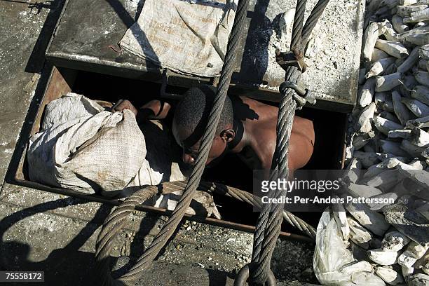 An unidentified crewmember checks cargo under deck on March 29, 2006 in Bumba, Congo, DRC. He works with many other young crewmembers without any...