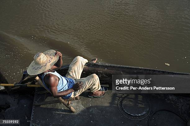 Crewmember relaxes on a cargo boat on April 4, 2006 in Bumba, Congo, DRC. He works on a cargo and passenger that is traveling from Kisangani to...