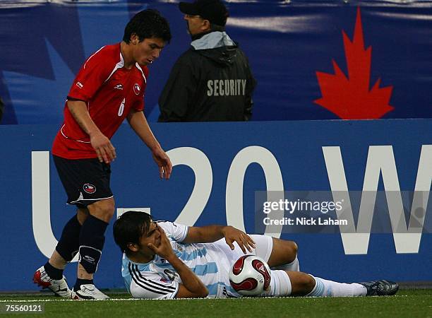 Gabriel Mercado of Argentina holds his face after Gary Medel of Chile lashed out at him, resulting in Medel receiving a red card during their...