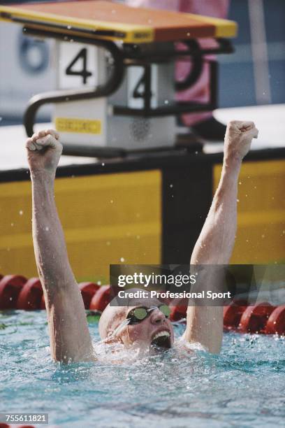 American swimmer Nelson Diebel pictured with his arms in the air in celebration after finishing in first place in an Olympic record time of 1 minute...