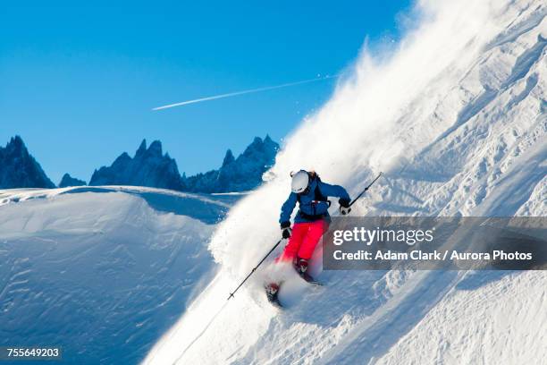 skier skiing through fresh powder down steep mountainside, chamonix, france - chamonix imagens e fotografias de stock