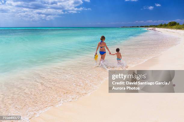 mother with daughter walking on beach of caribbean sea, cozumel, quintana roo, mexico - cozumel fotografías e imágenes de stock