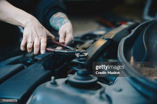 cropped image of female mechanic tightening nut on car engine with wrench - adjustable wrench stock pictures, royalty-free photos & images