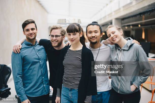 group portrait of confident male and female computer programmers standing together in office - alleen volwassenen stockfoto's en -beelden