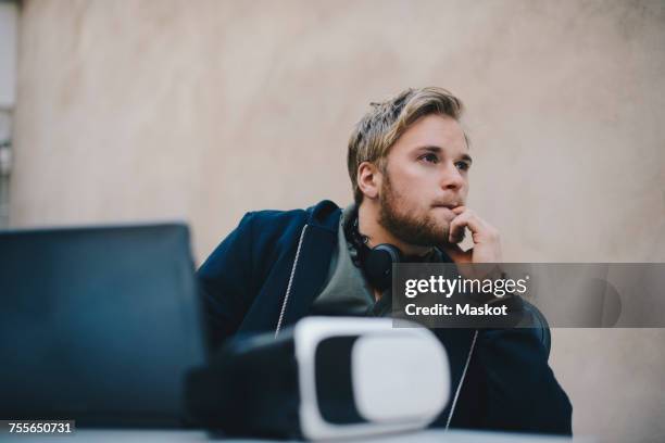 thoughtful computer programmer looking away while sitting at desk in office - nail biting stock pictures, royalty-free photos & images