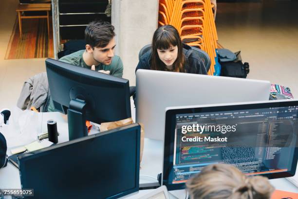 high angle view of computer programmers using desktop pc at office desk - digitale transformation stock-fotos und bilder