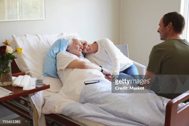 couple visiting senior man in hospital - hospital visit stock pictures, royalty-free photos & images