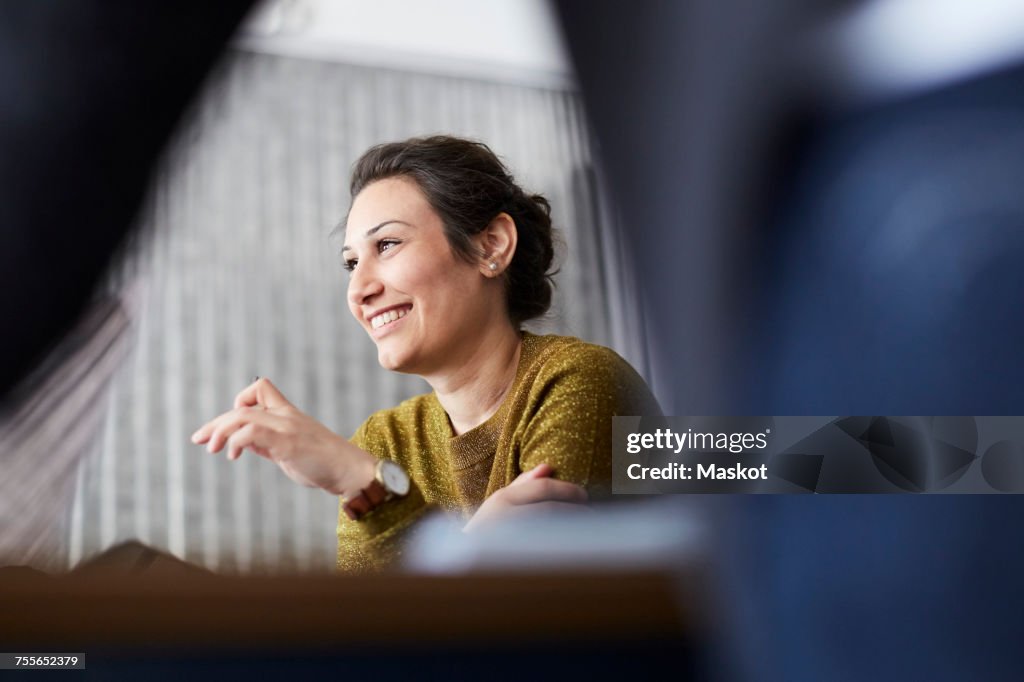 Smiling businesswoman sitting in front of female colleague at creative office