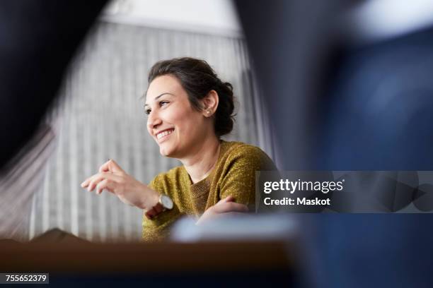 smiling businesswoman sitting in front of female colleague at creative office - selective focus meeting stock pictures, royalty-free photos & images