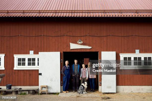 farmer standing with family at doorway of barn - australische herder stockfoto's en -beelden