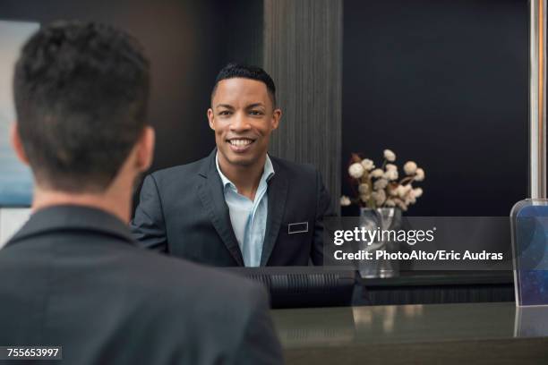 hotel receptionist greeting customer - concierge service stock pictures, royalty-free photos & images