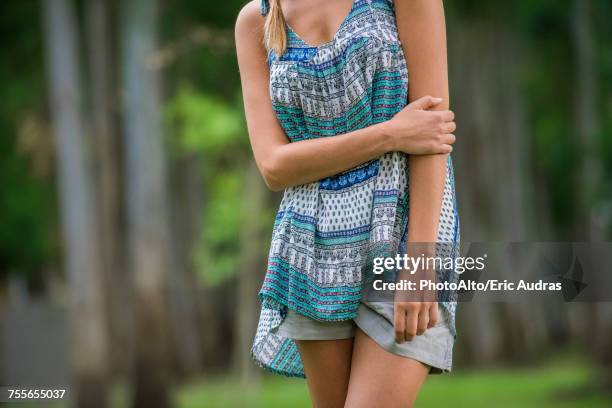 young woman standing with arm folded across stomach, cropped - sleeveless stock pictures, royalty-free photos & images