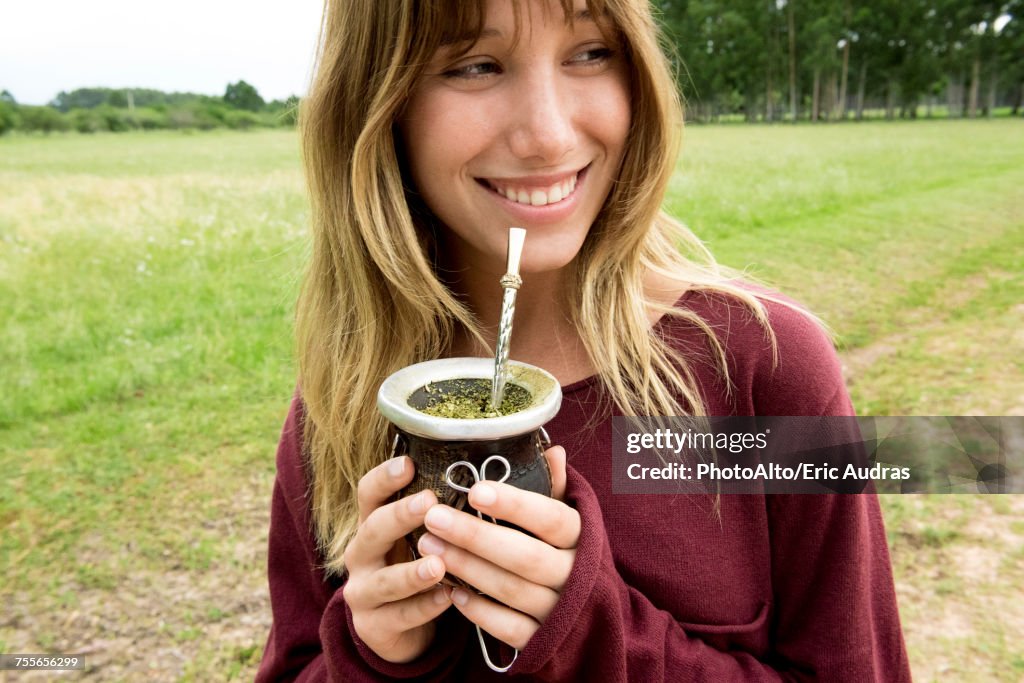 Young woman drinking mate in gourd
