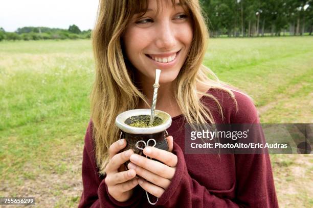 young woman drinking mate in gourd - mate argentina stock pictures, royalty-free photos & images