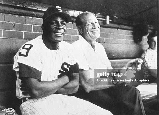 Outfielder Minnie Minoso, left, and owner Bill Veeck of the Chicago White Sox enjoy a laugh in the Comiskey Park dugout in 1957.