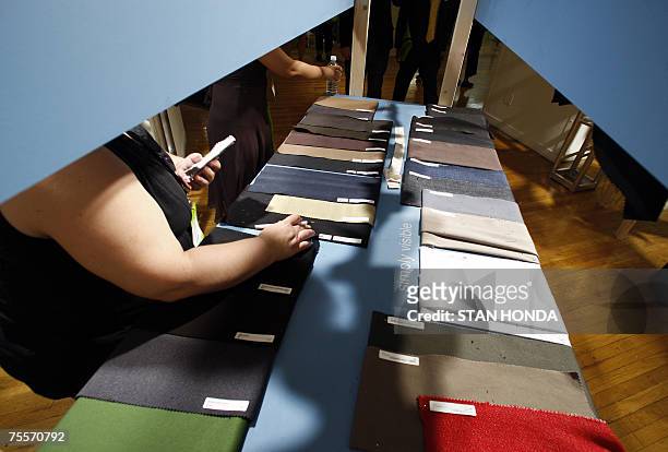 New York, UNITED STATES: TO GO WITH AFP STORY by Amandine AMBREGNI, USA-mode-tissus-salon Buyers inspect samples of the latest fabrics, 19 July 2007,...