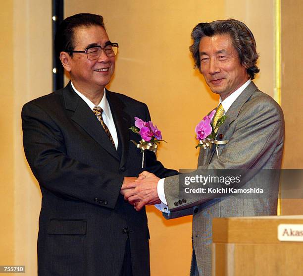 Li Peng, chairman of the Standing Committee of China's National People's Congress , and Japanese Prime Minister Junichiro Koizumi shake hands at a...