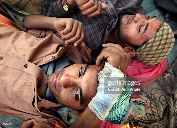 Salim Asif, who was injured after an attack on his home rests with his friend March 4, 2002 inside a mosque in central Ahmadabad, India. Over 5000...