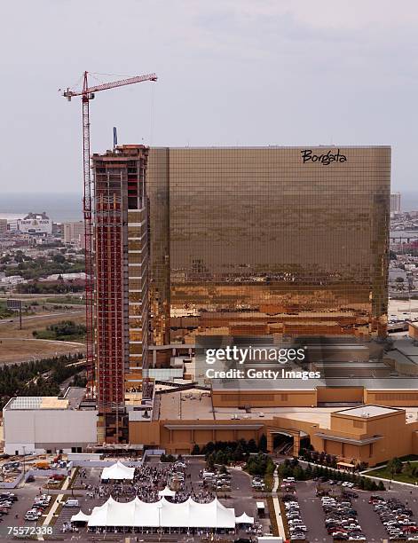 The last piece of vertical steel is raised into place atop the new Water Club Hotel in Atlantic City, New Jersey July 20, 2007. A large American flag...