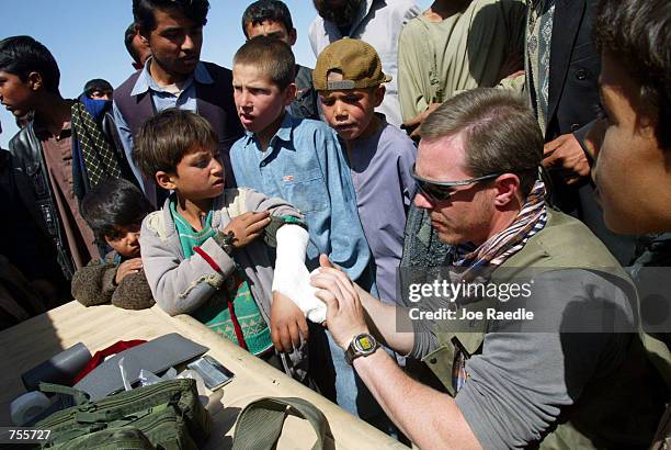 Staff Sgt. Michael Galaway from Abilene, TX puts a splint on a child's arm April 2, 2002 near the Bagram Air Base in Afghanistan. Galaway thought the...