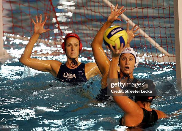 Teammates Elizabeth Armstrong and Moriah van Norman of the USA try to block a shot by Alison Braden of Canada in the women's water polo finals during...