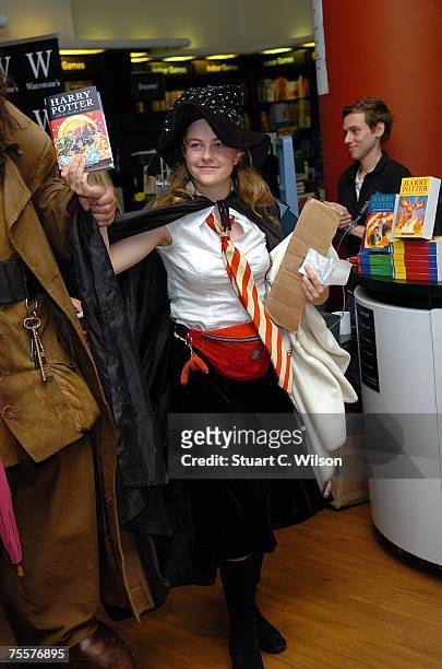 The first Harry Potter fan poses at the Waterstones Bookstore with the final book by author J.K. Rowling, "Harry Potter and the Deathly Hallows" on...