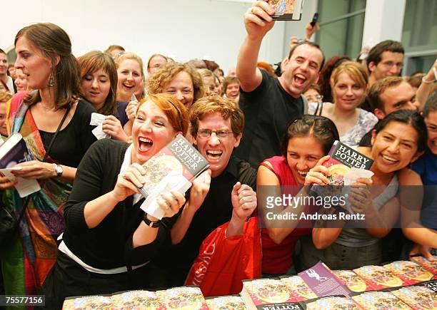 Fans hold the last book by J.K. Rowling "Harry Potter and the Deathly Hallows" in their hands at a bookstore after its release at 1:01am on July 21,...