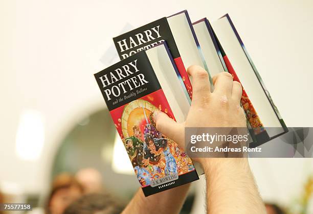 Customer holds the last book by J.K. Rowling "Harry Potter and the Deathly Hallows" in his hands at a bookstore after its release at 1:01am on July...