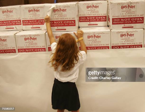Young Harry Potter fans rips away the wrapping paper to reveal unopened boxes of "Harry Potter and the Deathly Hallows" books prior to sale at the...