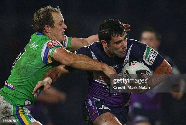 Michael Dobson of the Raiders tackles Cameron Smith of the Storm during the round 19 NRL match between the Melbourne Storm and the Canberra Raiders...