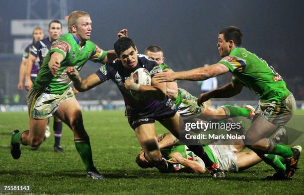 Greg Inglis of the Storm heads for the try line to score despite four Canberra defenders during the round 19 NRL match between the Melbourne Storm...